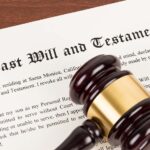 Last will and testament on yellowish paper with wooden judge gavel; document is mock-up