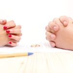 Closeup of a young man an a young woman signing a prenuptial agreement